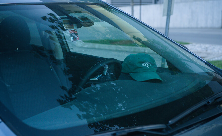 Image of car windshield reflecting light and showing only part of the inside of the vehicle